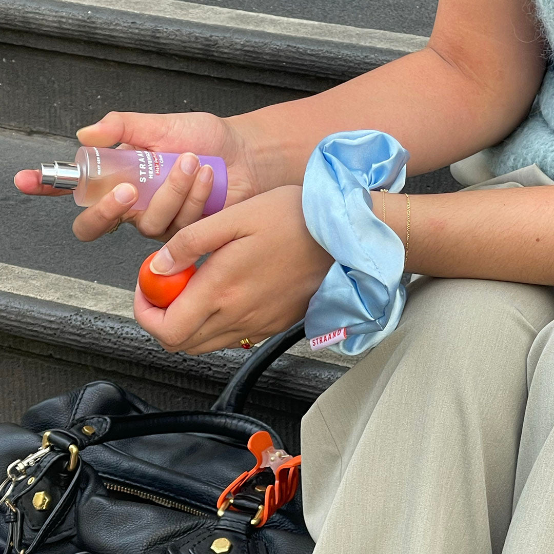 Hair perfume being pulled out of a handbag