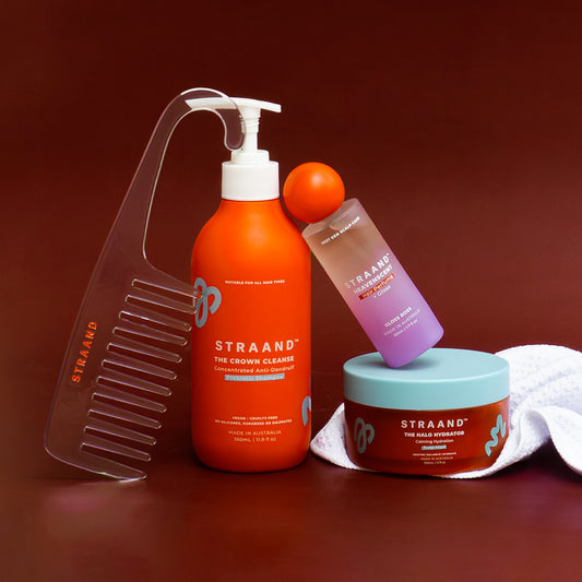 Comb, Shampoo, Hair perfume and scalp mask shown grouped together on a dark cherry red background