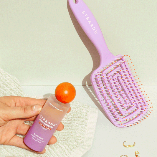 Animation of a hand grabbing a hair perfume with a hair brush that is purple left on the bench