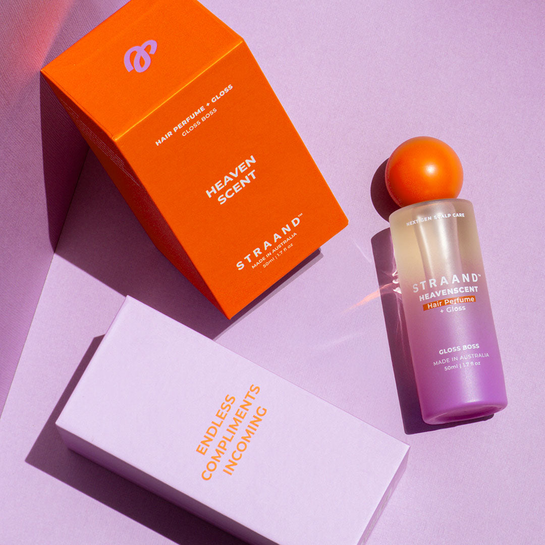 Hair perfume shown in it's purple and orange packaging