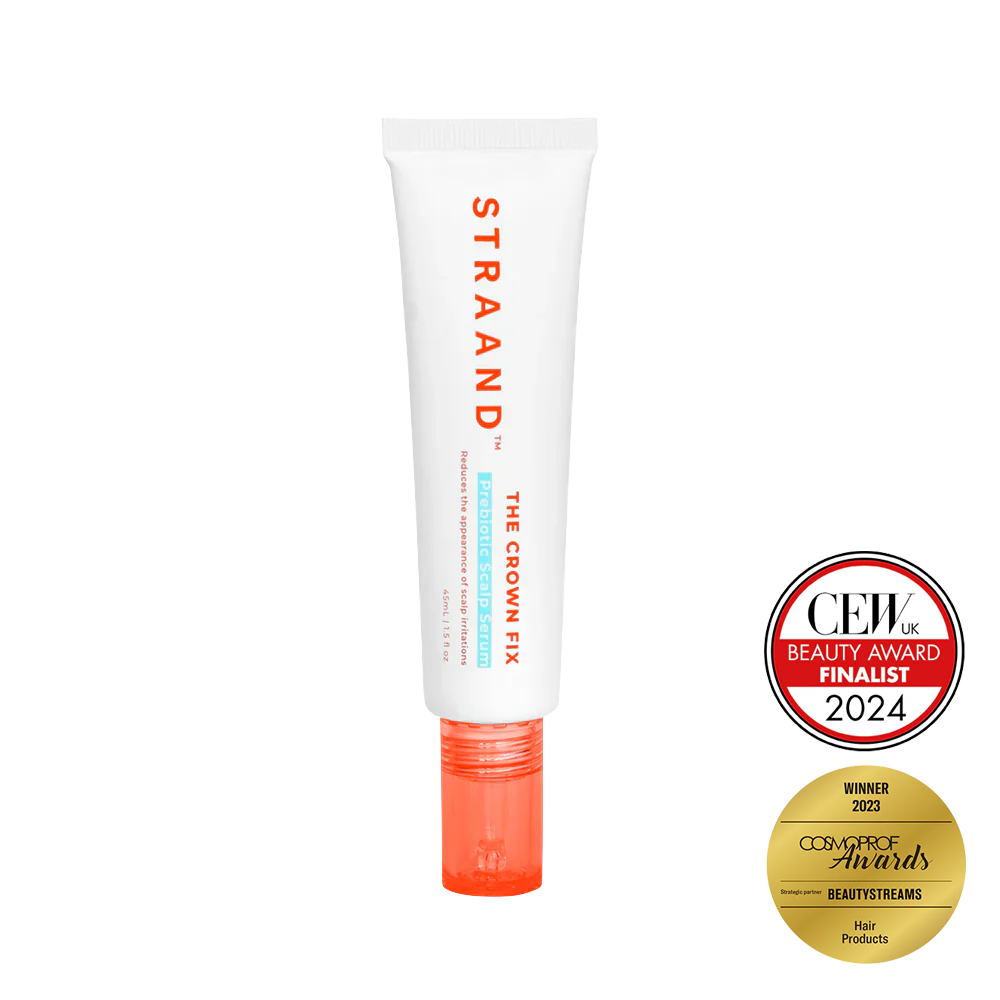 A bottle of 'The Crown Fix Scalp Serum' by STRAAND with a white body and red cap. It has text on the bottle and two seals indicating it as a Beauty Award Finalist and a Consumer Choice Award Winner.