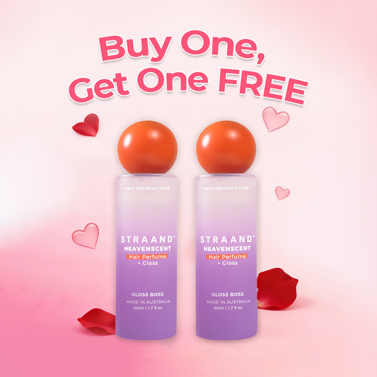 A bottle of HeavenScent Hair Perfume + Gloss with a purple label and a orange cap, indicating it is a hair care product.