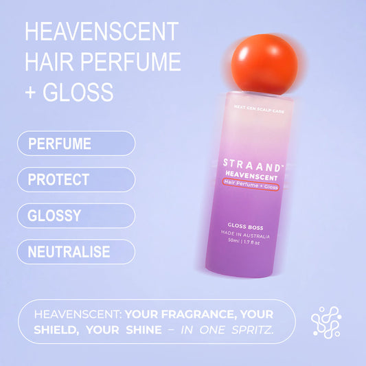 A bottle of HeavenScent Hair Perfume + Gloss with a purple label and a orange cap, indicating it is a hair care product.