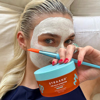 Elsa double masking using the Halo Hydrator on her hair and a skincare mask on her face.